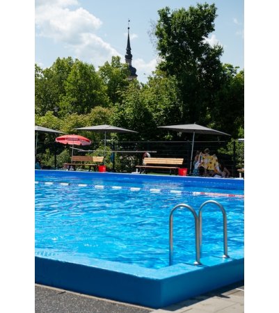 Schwimmbecken des Freibads Gnötzheim mit Kirchturm im Hintergrund